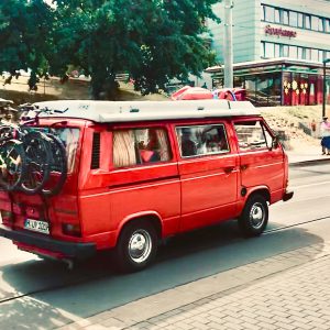 red and white volkswagen t-2 parked on sidewalk during daytime